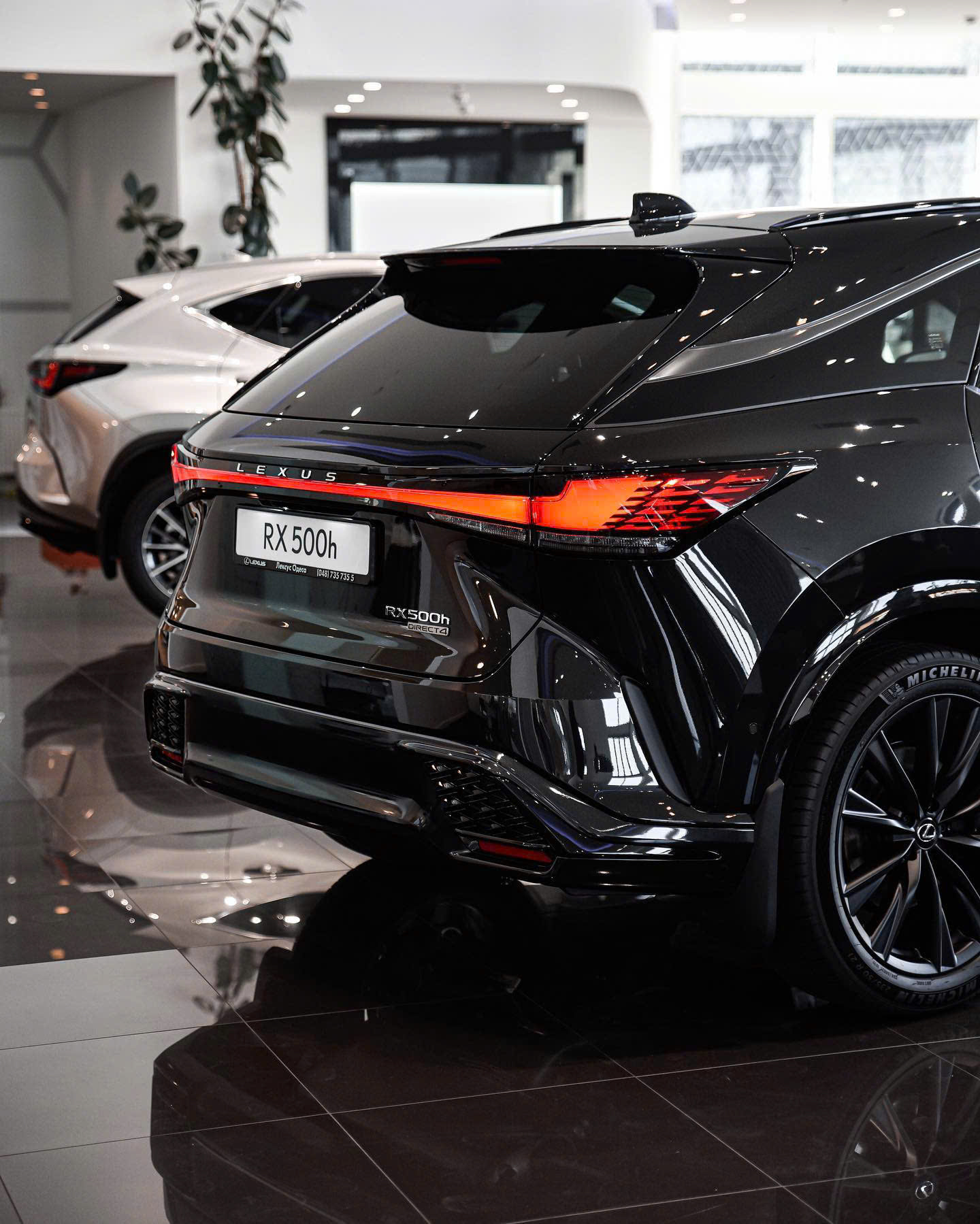 So Sánh Lexus RX 350h và RX 500h 2026: Khác Nhau Ở Đâu? 15 So Sánh Lexus RX 350h và RX 500h 2026: Khác Nhau Ở Đâu? Lexus RX 500h 2026 phía sau với huy hiệu DIRECT4